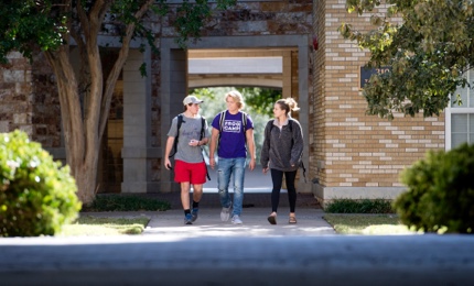 Three students walking on campus