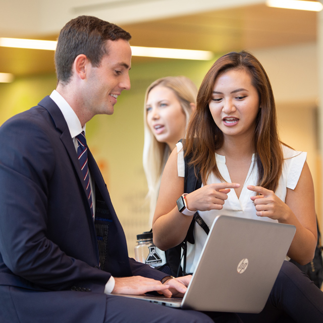 A female student points to a laptop.