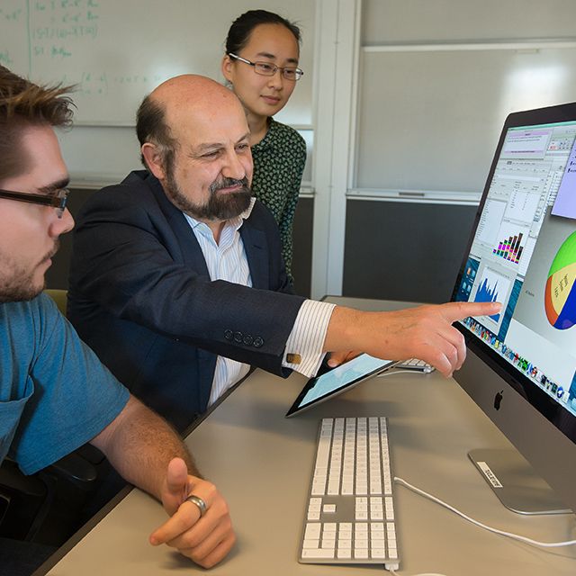 An instructors gestures toward a key datapoint within a data visualization on a computer screen