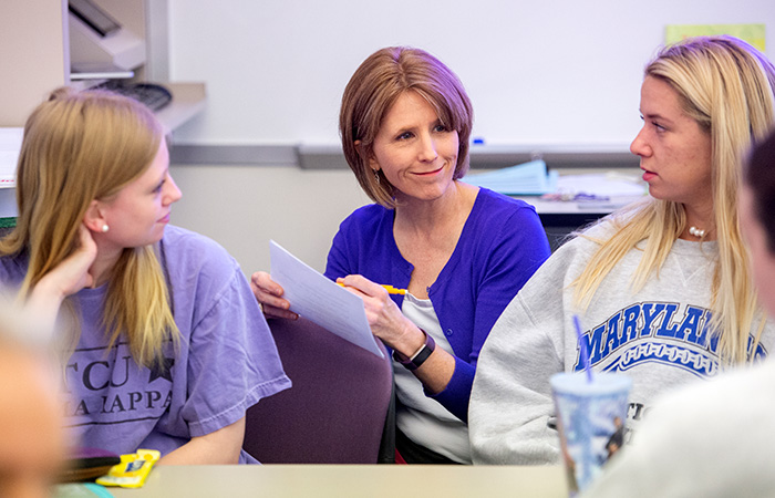 Female faculty with two students in conversation